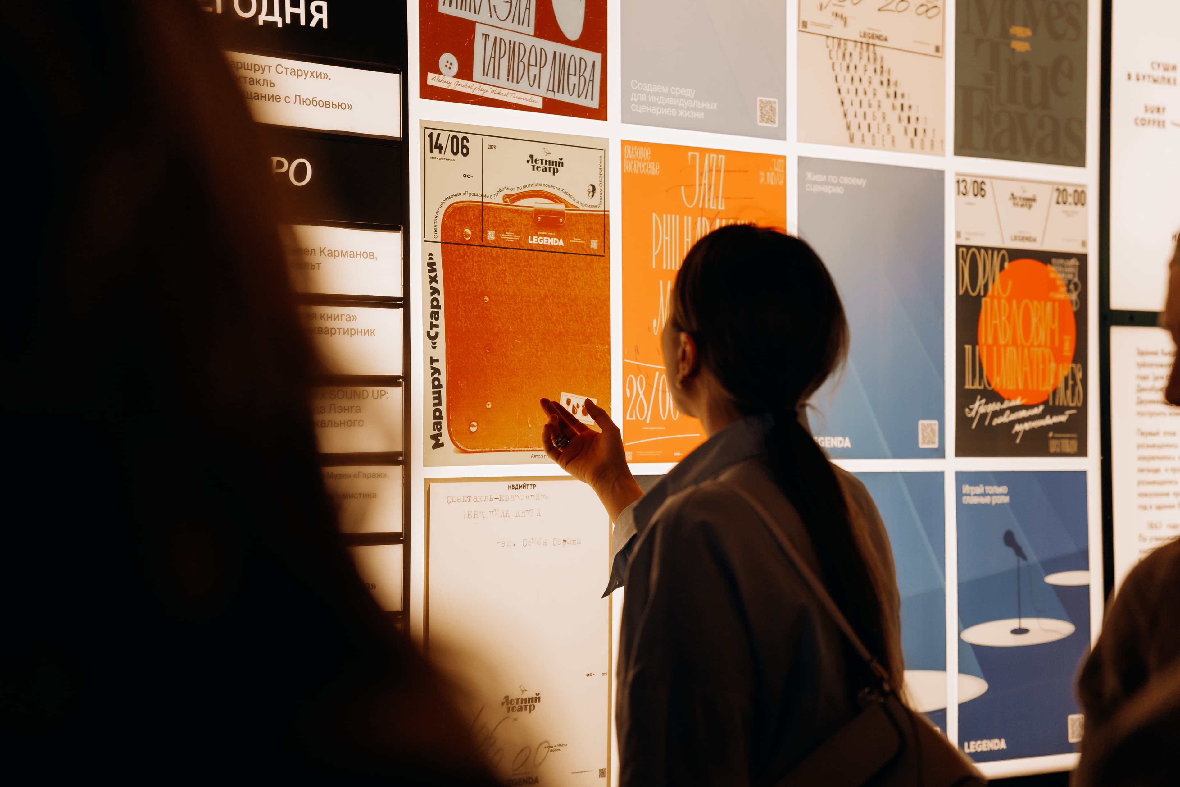 Visitor looking at posters on a light wall